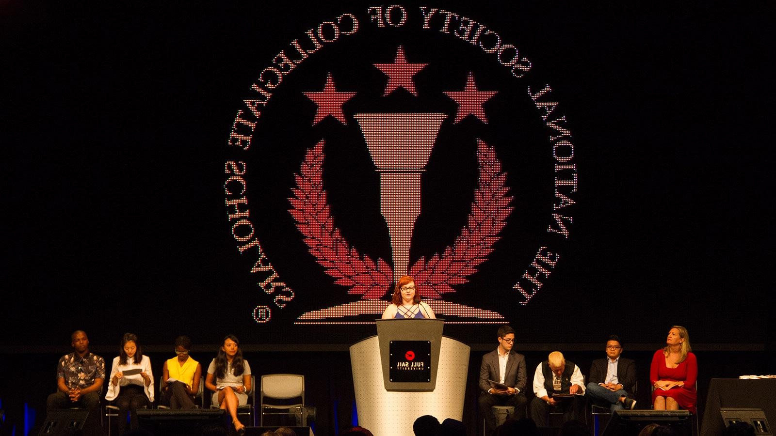 满帆的全国大学学者协会分会成员在NSCS仪式的舞台上.